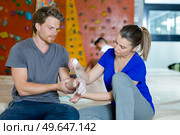 woman wrapping the male wall climbers wrist. Стоковое фото, агентство Ingram Publishing / Фотобанк Лори