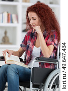 disabilty and handicap young disabled woman on wheelchair reads book. Стоковое фото, агентство Ingram Publishing / Фотобанк Лори