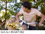 happy couple chasing on bike in the park. Стоковое фото, агентство Ingram Publishing / Фотобанк Лори
