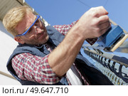 worker sanding the steel railing. Стоковое фото, агентство Ingram Publishing / Фотобанк Лори