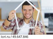 worker with yardstick- house in front of white background. Стоковое фото, агентство Ingram Publishing / Фотобанк Лори