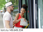 man helping woman board public transport she looks resentful. Стоковое фото, агентство Ingram Publishing / Фотобанк Лори