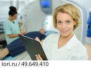 portrait of female doctor holding clipboard scanner in background. Стоковое фото, агентство Ingram Publishing / Фотобанк Лори