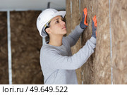 female construction worker installing insulation. Стоковое фото, агентство Ingram Publishing / Фотобанк Лори