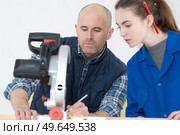 Young lady learning to use a chopsaw. Стоковое фото, агентство Ingram Publishing / Фотобанк Лори