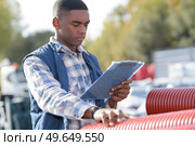 worker handling pipes outdoors. Стоковое фото, агентство Ingram Publishing / Фотобанк Лори