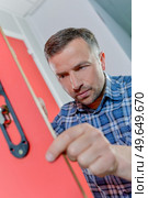 man is fixing a broken lock. Стоковое фото, агентство Ingram Publishing / Фотобанк Лори
