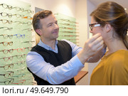 Optician fitting eyeglasses onto customer. Стоковое фото, агентство Ingram Publishing / Фотобанк Лори
