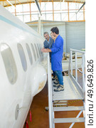 portrait of people inspecting aircraft fuselage. Стоковое фото, агентство Ingram Publishing / Фотобанк Лори