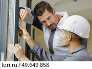 young glazier supervised by supervisor at work. Стоковое фото, агентство Ingram Publishing / Фотобанк Лори