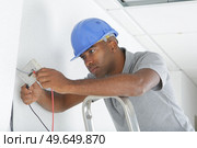 a man is installing wiring. Стоковое фото, агентство Ingram Publishing / Фотобанк Лори