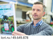 portrait of serious man reading catalogue. Стоковое фото, агентство Ingram Publishing / Фотобанк Лори