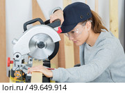 young woman using circular saw. Стоковое фото, агентство Ingram Publishing / Фотобанк Лори