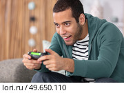 enthusiastic gamer with a joystick in his hands. Стоковое фото, агентство Ingram Publishing / Фотобанк Лори