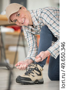 happy woman laces up safety boots. Стоковое фото, агентство Ingram Publishing / Фотобанк Лори