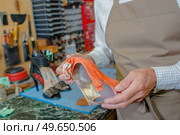 a man is holding sandals. Стоковое фото, агентство Ingram Publishing / Фотобанк Лори