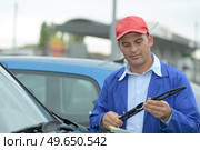 man hand picking up windscreen wiper. Стоковое фото, агентство Ingram Publishing / Фотобанк Лори