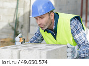 a construction worker bricklaying the wall indoors. Стоковое фото, агентство Ingram Publishing / Фотобанк Лори