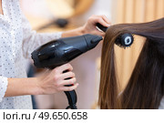 rearview cropped close up of a professional stylist drying hair. Стоковое фото, агентство Ingram Publishing / Фотобанк Лори