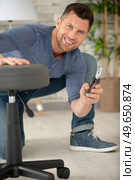 man is assembling an office chair. Стоковое фото, агентство Ingram Publishing / Фотобанк Лори