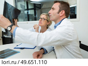 radiography specialists inspecting an xray result. Стоковое фото, агентство Ingram Publishing / Фотобанк Лори
