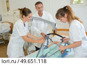 Nurses moving patient with hoist. Стоковое фото, агентство Ingram Publishing / Фотобанк Лори