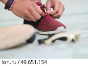 sportsman adjusting shoelace beside eyewear bat and ball. Стоковое фото, агентство Ingram Publishing / Фотобанк Лори