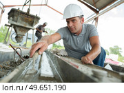 mature worker levelling cement with trowel. Стоковое фото, агентство Ingram Publishing / Фотобанк Лори