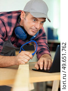 shot of a smiling carpenter using laptop. Стоковое фото, агентство Ingram Publishing / Фотобанк Лори