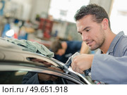 Man buffing roof of car with machine. Стоковое фото, агентство Ingram Publishing / Фотобанк Лори