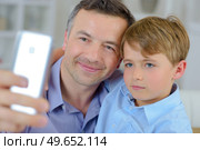 a father and son taking a picture. Стоковое фото, агентство Ingram Publishing / Фотобанк Лори