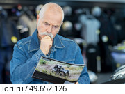 elderly man reading a catalogue indoors. Стоковое фото, агентство Ingram Publishing / Фотобанк Лори