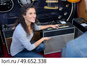 Lady showing amplifier to customer. Стоковое фото, агентство Ingram Publishing / Фотобанк Лори