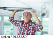 a man repairing collapsed ceiling. Стоковое фото, агентство Ingram Publishing / Фотобанк Лори