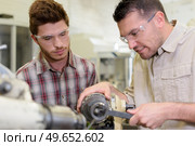 men mending a machine with goggles on. Стоковое фото, агентство Ingram Publishing / Фотобанк Лори