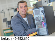 a male worker with a central processing unit. Стоковое фото, агентство Ingram Publishing / Фотобанк Лори