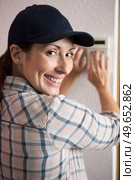 female electrician installing a intercom. Стоковое фото, агентство Ingram Publishing / Фотобанк Лори