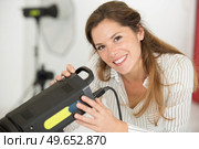 female photographer adjusting flash strobe. Стоковое фото, агентство Ingram Publishing / Фотобанк Лори