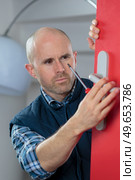 Man fitting door handle. Стоковое фото, агентство Ingram Publishing / Фотобанк Лори