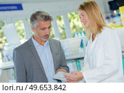 portrait of pharmacist advising suited man. Стоковое фото, агентство Ingram Publishing / Фотобанк Лори