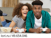 happy excited young couple playing videogames. Стоковое фото, агентство Ingram Publishing / Фотобанк Лори
