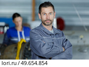 mechanic looking to camera beside a car. Стоковое фото, агентство Ingram Publishing / Фотобанк Лори