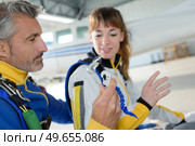 Instructor showing equipment to skydiver. Стоковое фото, агентство Ingram Publishing / Фотобанк Лори