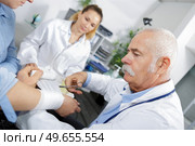 doctor bandaging male hand sprained wrist. Стоковое фото, агентство Ingram Publishing / Фотобанк Лори