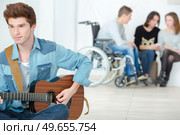 handicapped devoted musician playing guitar. Стоковое фото, агентство Ingram Publishing / Фотобанк Лори