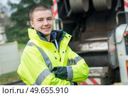 young garbage collector standing near his truck. Стоковое фото, агентство Ingram Publishing / Фотобанк Лори