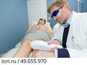 close-up of ma giving laser epilation treatment to young woman. Стоковое фото, агентство Ingram Publishing / Фотобанк Лори