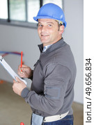 male builder in hard hat holds clipboard. Стоковое фото, агентство Ingram Publishing / Фотобанк Лори