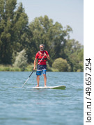 man enjoying a ride on the lake with paddleboard. Стоковое фото, агентство Ingram Publishing / Фотобанк Лори