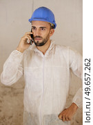 male builder wearing overalls talking on telephone. Стоковое фото, агентство Ingram Publishing / Фотобанк Лори